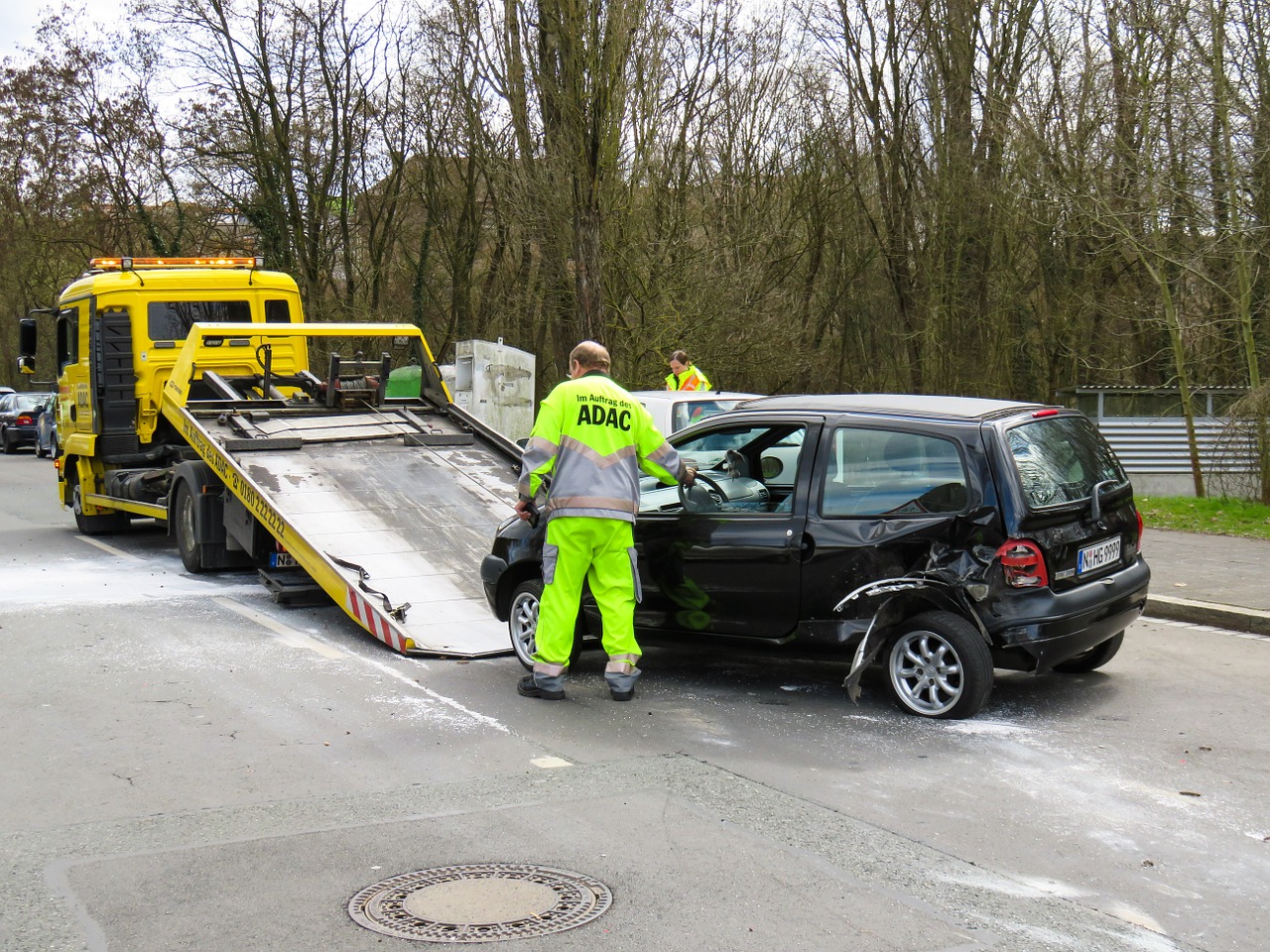 Tow Truck Insurance Hopkinsville KY - Worker loading black van onto yellow flatbed truck